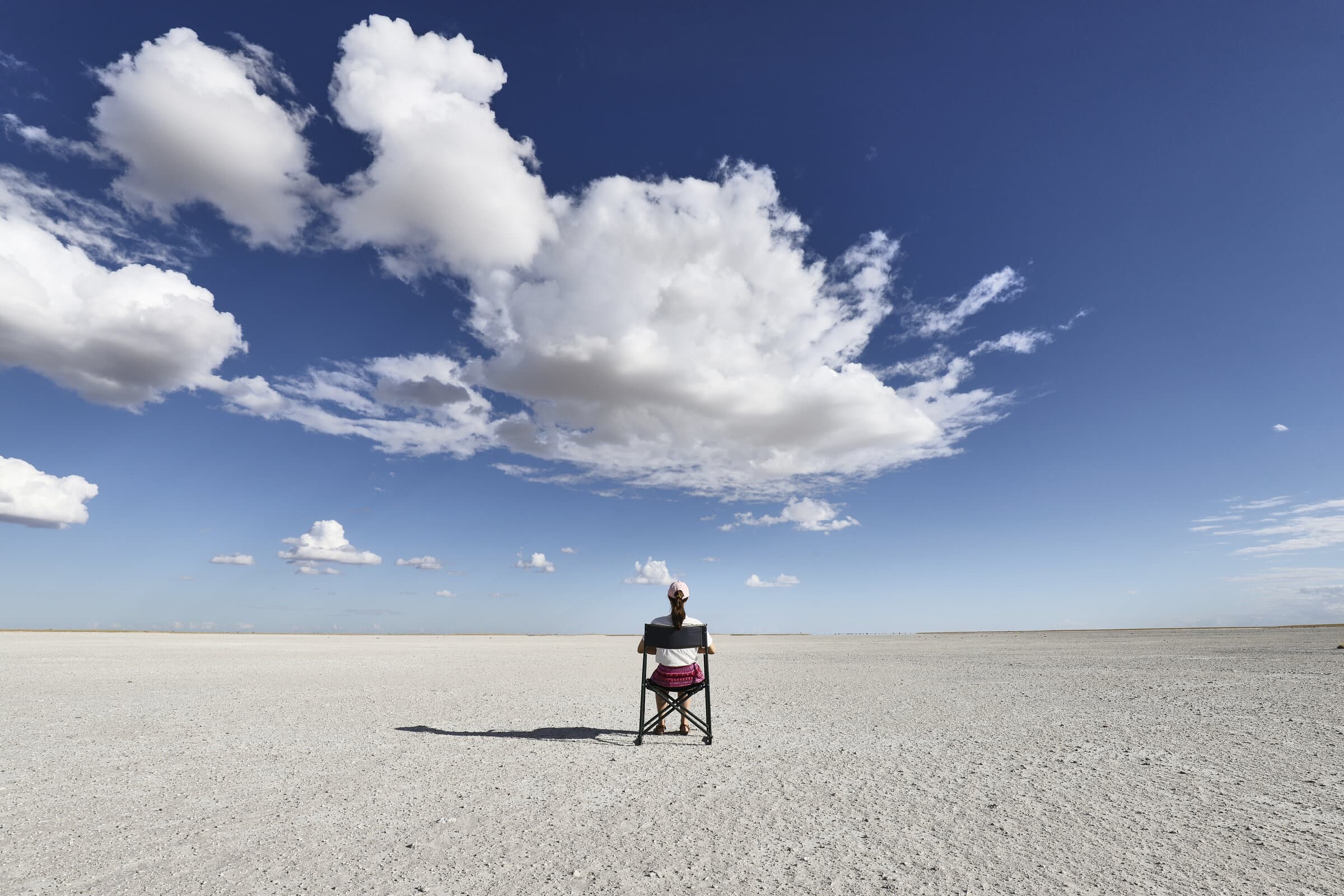Person sitting alone on a vast salt flat