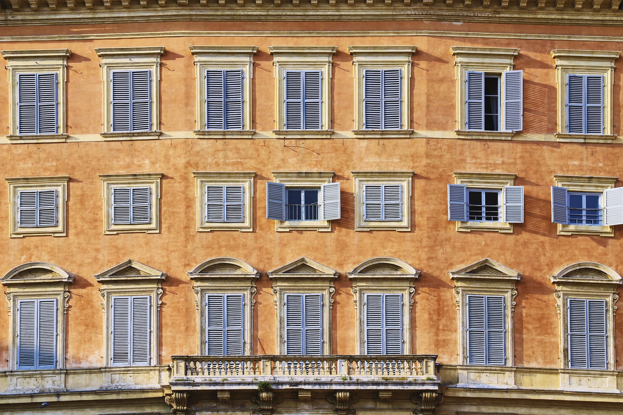 Orange Mediterranean building with blue shutters
